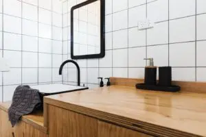Bathroom vanity made of wood with tiled walls in the background
